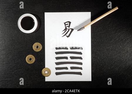 Gros plan d'un arrangement I Ching sur l'ardoise avec le 63ème hexagramme (après la complition/Chi Chi) écrit avec une brosse à encre chinoise sur du papier de riz. Banque D'Images