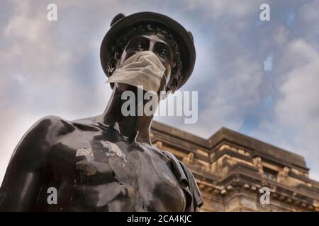 La statue de la Mercurial dans la rue Glasgow a été transformée en symbole du coronavirus (Covid 19) en portant un masque protecteur. Banque D'Images