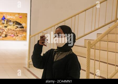 YOGYAKARTA, RÉGION SPÉCIALE DE YOGYAKARTA, INDONÉSIE. 4 août 2020. Une femme se selfie avec un téléphone portable tout en regardant une exposition de peinture sur le thème « Duwow » pour démarrer un nouvel ordre de vie dans un contexte d'épidémie de virus corona à la Galerie Jogja, Yogyakarta, Indonésie, le mardi 4 août 2020. Le cas positif du virus corona en Indonésie aujourd'hui est de 115,056 personnes . Auparavant, le Président de l'Indonésie, Joko Widodo, a averti qu'il devait être vigilant quant à la possibilité et à l'anticipation du risque d'une deuxième vague, la deuxième. Credit: Slamet Riyadi/ZUMA Wire/Alamy Live News Banque D'Images