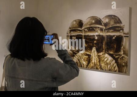 YOGYAKARTA, RÉGION SPÉCIALE DE YOGYAKARTA, INDONÉSIE. 4 août 2020. Les visiteurs prennent des photos avec leur téléphone portable tout en regardant l'exposition de peinture sur le thème « Duwow » pour commencer un nouvel ordre de vie dans le cadre d'une épidémie de virus corona à la galerie Jogja, Yogyakarta, Indonésie, le mardi 4 août 2020. Le cas positif du virus corona en Indonésie compte aujourd'hui 115,056 personnes. Auparavant, le Président de l'Indonésie, Joko Widodo, a averti qu'il devait être vigilant quant à la possibilité et à l'anticipation du risque d'une deuxième vague, la deuxième. Credit: Slamet Riyadi/ZUMA Wire/Alamy Live News Banque D'Images