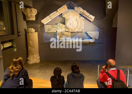 Visiteurs au Bath Museum Apprenez sur les vestiges du Temple Pediment - Gorgon's Head, The Roman Baths Museum, Bath, Somerset, Angleterre, Royaume-Uni Banque D'Images