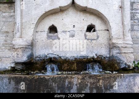 Avant gros plan de la fontaine à boire en pierre avec de l'eau du Moyen âge Banque D'Images