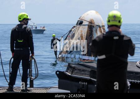 Des équipes de soutien arrivent à bord du vaisseau spatial SpaceX Crew Dragon Endeavour peu après son atterrissage avec les astronautes de la NASA Robert Behnken et Douglas Hurley dans le golfe du Mexique, au large de la côte de Pensacola, en Floride, le 2 août 2020. Le vol d'essai Demo-2 pour le programme des équipages commerciaux de la NASA a été le premier à livrer des astronautes à la Station spatiale internationale et à les ramener sur Terre en toute sécurité à bord d'un vaisseau spatial construit et exploité commercialement. Behnken et Hurley sont revenus après avoir passé 64 jours dans l'espace. NASA photo par Bill Ingalls/UPI Banque D'Images