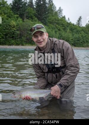 Terrace, Canada - 20 juillet 2017 : pêcheur à la ligne tenant un saumon rose capturé sur la rivière Kitimat, région de Skeena, Colombie-Britannique, Canada Banque D'Images