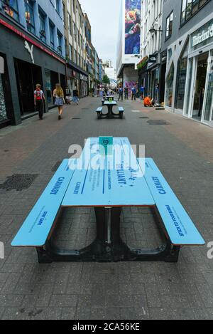 Londres, Royaume-Uni. 4 août 2020. Des tables de pique-nique ont été mises en place dans Carnaby Street, ce qui permet aux gens de manger des plats à emporter. La signalisation sur les tables rappelle aux gens de continuer à s'éloigner socialement à mesure que la pandémie du coronavirus se poursuit. Credit: Stephen Chung / Alamy Live News Banque D'Images