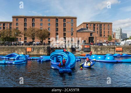 Parc aquatique avec parcours flottant de toboggans gonflables et obstacles d'escalade à Albert Dock, Liverpool, Merseyside, Royaume-Uni Banque D'Images