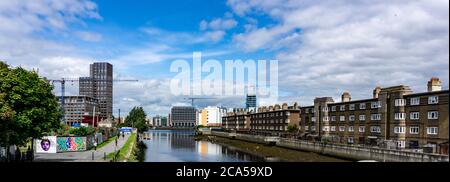 L'ancien logement public de Ringsend à droite de la photo est séparé par la rivière Dsurder des développements modernes du Grand Canal à Dublin. Banque D'Images