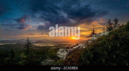 Ciel spectaculaire au coucher du soleil avec nuages illuminés dans les montagnes. Silhouette noire sombre de crête de montagne et tour d'émetteur de Jested au fond, sombre Banque D'Images