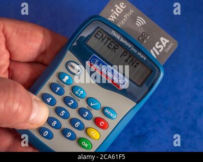 Main d'un homme utilisant un lecteur de carte national avec une instruction de SAISIR le code PIN. (Un code de sécurité temporaire est alors saisi pour accéder aux services bancaires sur Internet). Banque D'Images