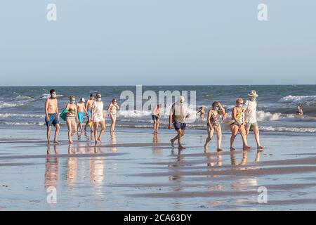 Punta Umbria, Huelva, Espagne - 2 août 2020: Beaucoup de personnes marchant sur la plage portant des masques protecteurs ou médicaux. Nouvelle norme en Espagne avec Banque D'Images