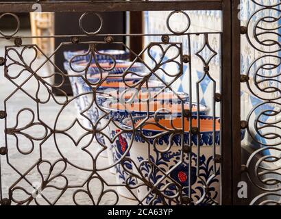 Pots de fleurs en céramique grenadienne dans un patio derrière une magnifique grille en fer forgé Banque D'Images