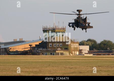 Le corps d'aviation de l'armée Apache attaque l'air de l'hélicoptère qui passe devant la tour de contrôle de Wattisham après le retour d'un vol. Banque D'Images