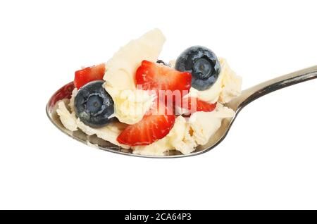 Fraises, bleuets, meringue et crème fraîche épaisse dans une cuillère isolée du blanc Banque D'Images