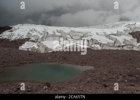 Un grand glacier tropical haut dans les Andes péruviennes se rétrécit et fond lentement, l'eau de fonte s'en échappe. Il ne peut durer plus de quelques décennies. Banque D'Images