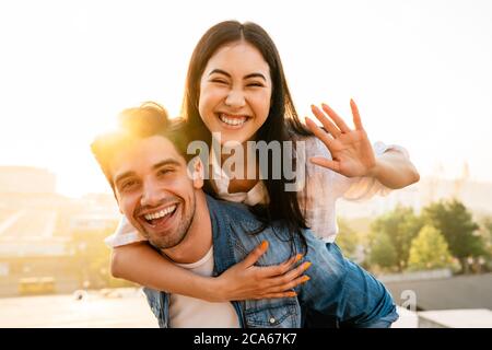 Image d'un couple multiculturel et joyeux en train de se promener et de se promener à l'extérieur Banque D'Images