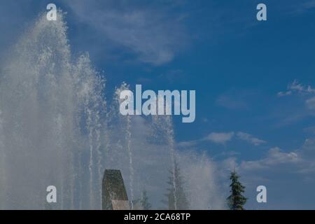 Jets d'eau de fontaine sur un fond bleu ciel d'été gros plan. Banque D'Images