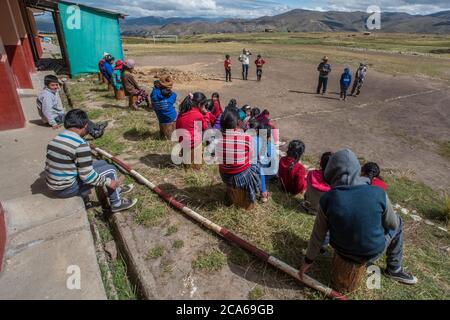 Les enfants quechua d'une communauté andine se réunissent à l'extérieur pour écouter un conférencier éducatif au Pérou. Banque D'Images