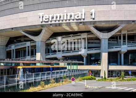 Une navette aéroport CDGVAL est en service à la gare au pied du bâtiment circulaire en béton du terminal 1 de l'aéroport Paris-Charles de Gaulle. Banque D'Images