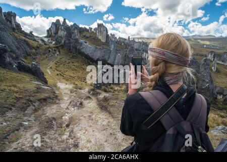 Un randonneur dans une forêt de pierre dans une région éloignée des Andes prend une photo du paysage avec son téléphone. Banque D'Images