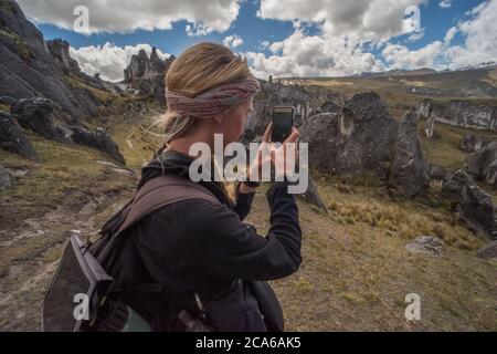 Un randonneur dans une forêt de pierre dans une région éloignée des Andes prend une photo du paysage avec son téléphone. Banque D'Images