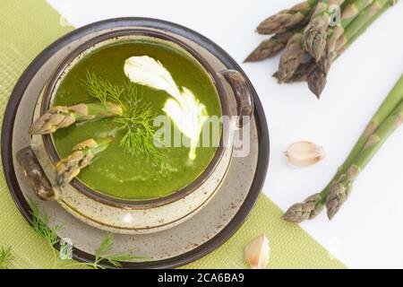 Soupe d'asperges au printemps vert dans un bol décoré d'aneth et de crème. Vue de dessus. Banque D'Images