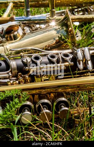 Des instruments de musique, dont la clarinette en trompette trombone et le saxophone, se trouvent dans un champ herbacé au festival de musique Banque D'Images