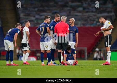 Londres, Royaume-Uni. 04e août 2020. Christian Nørgaard de Brentford est assis sur le terrain tandis que le Référentiel Martin Atkinson parle à Saïd Benrahma de Brentford lors du match final de jeu du championnat Sky Bet, entre Brentford et Fulham, au stade Wembley, Londres, Angleterre, le 4 août 2020. Les stades de football restent vides en raison de la pandémie de Covid-19, car les lois de distanciation sociale du gouvernement interdisent aux supporters à l'intérieur des lieux, ce qui entraîne le jeu de tous les présentoirs derrière des portes fermées jusqu'à nouvel ordre. Photo par Andrew Aleksiejczuk/Prime Media Images. Crédit : Prime Media Images/Alamy Live News Banque D'Images