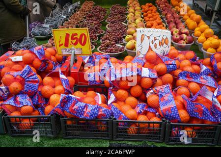 Londres, Royaume-Uni - 04 février 2019 : sacs d'oranges et plus de fruits dans des bols exposés sur le marché traditionnel des fruits de Lewisham. Banque D'Images