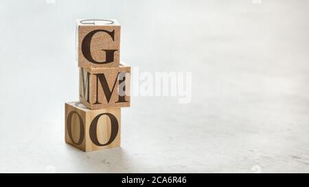 Pile avec trois cubes en bois - lettres OGM signifiant organisme génétiquement modifié sur eux, espace pour plus de texte / images sur le côté droit. Banque D'Images