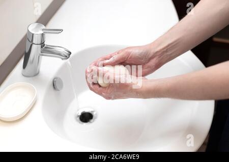 Lavage des mains. L'homme lave soigneusement ses mains avec du savon dans la salle de bains. Prévention du coronavirus. Hygiène personnelle. Banque D'Images