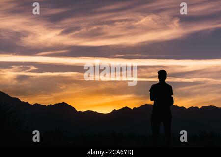 jeune homme debout à l'heure d'or devant La montagne des Andes r Banque D'Images