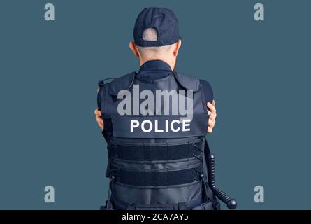 Jeune homme beau portant l'uniforme de police se embrassant heureux et positif de l'arrière-plan. Amour de soi et de soins de soi Banque D'Images