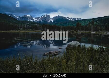 Coucher de soleil sur le lac Sprague dans les montagnes rocheuses du colorado. Les gens pêchent à l'ombre de la magnifique chaîne de montagnes Banque D'Images