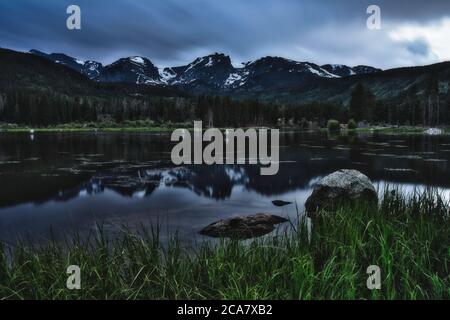 Coucher de soleil sur le lac Sprague dans les montagnes rocheuses du colorado. Les gens pêchent à l'ombre de la magnifique chaîne de montagnes Banque D'Images