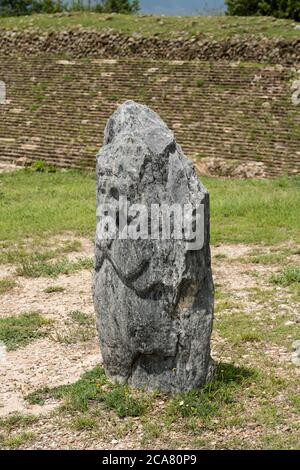 Une stela en pierre sculptée se trouve sur la plate-forme au-dessus de la cour de balle sur les ruines précolombiennes de Zapotec de Monte Alban à Oaxaca, au Mexique. Un monde de l'UNESCO il Banque D'Images