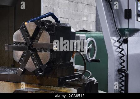 arrière-plan industriel - détail de la machine-outil, mandrin de broche de tour avec six mâchoires sur la contrepointe Banque D'Images