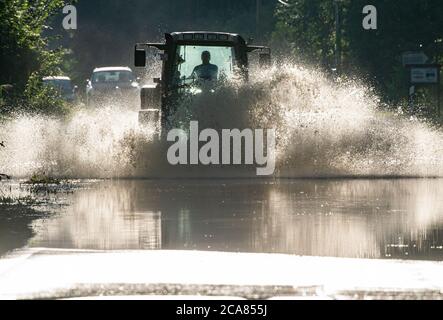 Raubling, Allemagne. 05 août 2020. Un tracteur roule sur une route qui est sous l'eau en raison de la forte pluie des derniers jours. Credit: Peter Kneffel/dpa/Alay Live News Banque D'Images