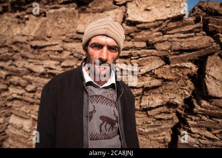 Xinaliq / Azerbaïdjan - 8 juillet 2019 : Portrait de l'homme devant un mur traditionnel fait de boue et de paille Banque D'Images