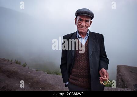 Xinaliq / Azerbaïdjan - 8 juillet 2019 : Portrait d'un homme musulman qui priait avec un jeton dans la main contre le brouillard en arrière-plan Banque D'Images