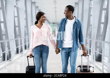 Juste marié Black couple marcher avec des valises à l'aéroport, aller à lune de miel Banque D'Images