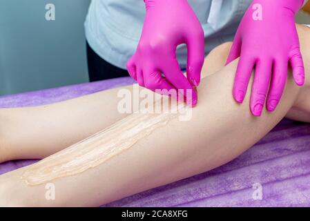 Femme ayant une procédure d'épilation sur les jambes dans un salon de beauté Banque D'Images
