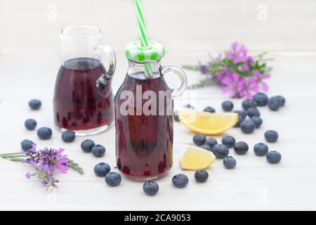 Bleuets et jus de myrtille sur tableau blanc. Myrtille ou jus d'aronia frais faits maison. Banque D'Images