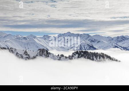 Montagnes enneigées avec brouillard de vallée d'inversion et arbres enveloppés de brume. Paysage hivernal pittoresque et enneigé dans les Alpes, Allgau, Kleinwalsertal, Bavière Banque D'Images