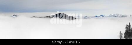 Hiver vue panoramique sur les montagnes enneigées au-dessus des nuages de brouillard d'inversion. Vue de Riedberger Horn à Allgau, Bavière, Allemagne. Banque D'Images