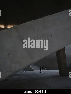 Un visiteur passant par, sous la structure. Le Dongdaemun Design Plaza, Séoul, Corée du Sud. Architecte: Zaha Hadid Architects, 2014. Banque D'Images