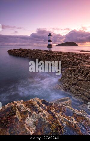 Lever de soleil sur l'Penmon Point Lighthouse, Anglesey, au nord du Pays de Galles, Royaume-Uni, Europe Banque D'Images