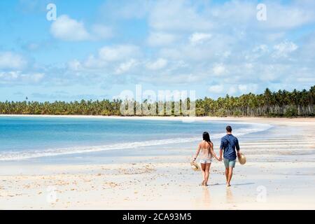 Un bon-look hispanique (latin) couple marchant sur une plage déserte avec dos à la caméra, Brésil, Amérique du Sud Banque D'Images