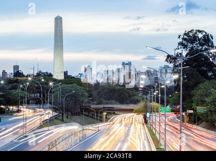 Les feux de circulation de l'heure de pointe sur l'avenue 23 de Maio, la ligne d'horizon et l'obélisque des héros dans le parc Ibirapuera, Sao Paulo, Brésil, Amérique du Sud Banque D'Images