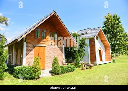 maison dans le jardin avec jour d'été / maison de paysage dans la ferme dans le champ vert avec un ciel soupir et le soleil et les arbres verts Banque D'Images