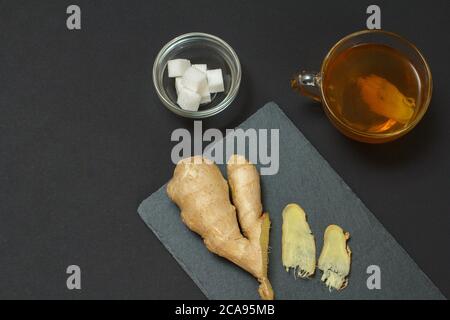 Aliments de remède de santé pour le soulagement du rhume et de la grippe avec le gingembre et le thé sur fond noir. Vue de dessus. Aliments qui stimulent le système immunitaire. Banque D'Images
